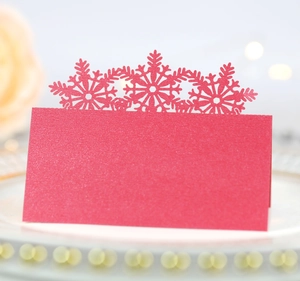 Close-up of red glitter place card with laser-cut snowflake details on elegant tray