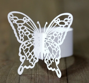 Detailed view of laser-cut white butterfly napkin ring with hollow patterns for weddings