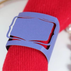 Portatovagliolo in carta viola con intaglio a laser su tovagliolo rosso a maglia