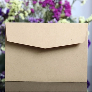 Minimalist brown kraft paper envelope with V-flap closure on dark reflective surface