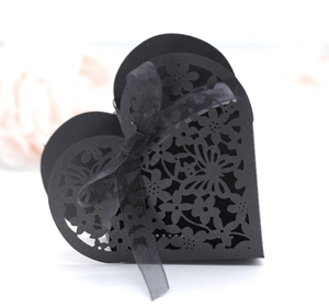 Detail of laser-cut hollow heart candy box in black cardstock with silk ribbon bow