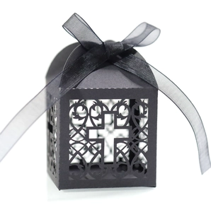 Détail de la boîte cadeau noire découpée au laser avec motif de croix et nœud en satin