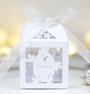 Détail de la boîte à bonbons blanche avec oiseau découpé au laser et ruban en organza