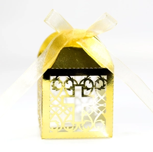 Vue détaillée de la boîte à dragées dorée ajourée avec croix et ruban satiné jaune