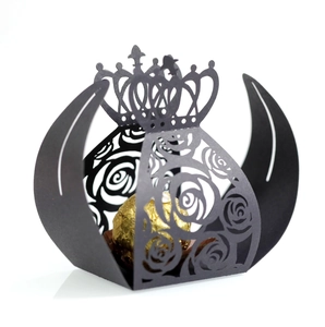 Detail of laser-cut black crown favor box with rose patterns for wedding candies