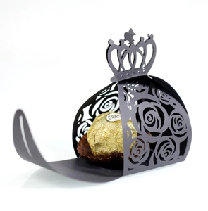 Detail of black laser-cut candy box with rose pattern and elegant crown top decoration