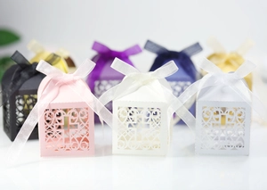 Vue détaillée des boîtes à bonbons croix ajourées avec rubans colorés pour mariages