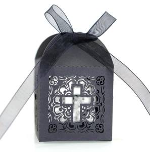 Detailed close-up of a black laser-cut candy box with a cross pattern and organza ribbon