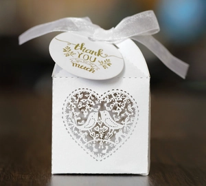 Detail der weißen Geschenkbox mit Laserschnitt-Vogelmuster und Danksagungskarte