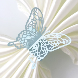 Elegant laser-cut butterfly napkin ring in light blue pearlescent paper on white satin