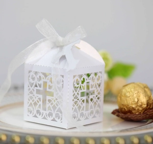Vue détaillée de la boîte à dragées blanche découpée au laser avec motif de croix et ruban