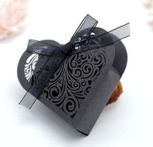 Detailed laser-cut heart pattern on a black wedding favor box with a satin bow