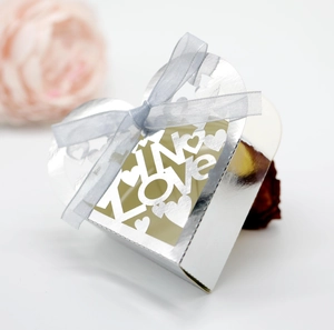 Macro detail of silver mirror LOVE candy box with hollow hearts and blue ribbon