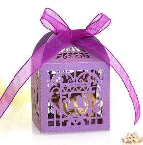 Dettaglio della scatola regalo viola intagliata al laser con nastro e cioccolatini interni