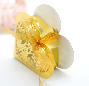 Macro detail of golden laser-cut heart candy box with elegant organza ribbon bow