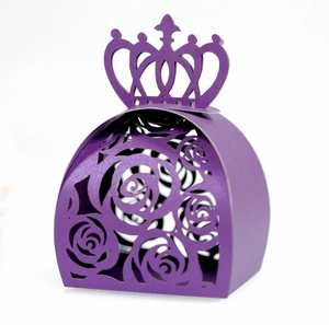 Detail of laser-cut purple paper candy box with crown handle and hollow rose patterns