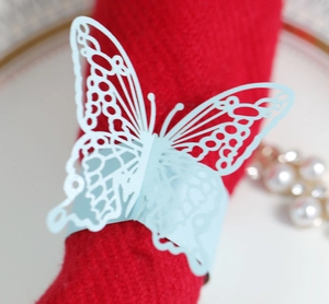 Close-up of light blue laser-cut butterfly napkin ring on a red wedding napkin