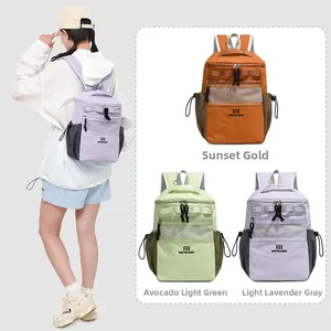 Detail of color-blocked nylon backpacks in orange, green, and purple with mesh pockets