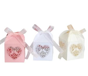 Pink and white laser-cut party favor boxes with love bird heart design and silk ribbons