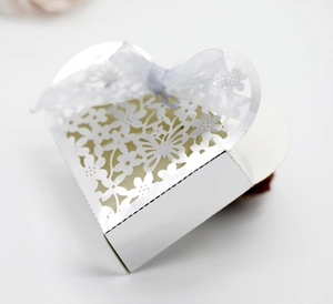Macro detail of silver heart hollow gift box with intricate laser-cut floral patterns