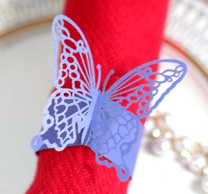 Detailed macro view of laser-cut purple butterfly napkin ring on a red napkin