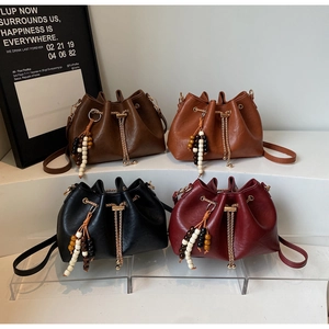 Detailed display of vintage drawstring bucket bags with unique beaded tassels and gold chains
