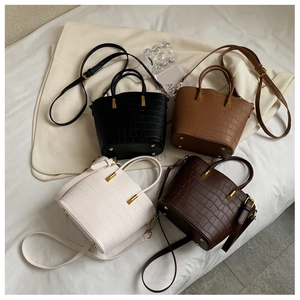 Top view of bucket bags in four colors featuring crocodile pattern and gold hardware