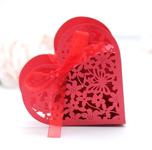 Detail of red heart laser-cut candy box with floral patterns and a ribbon bow