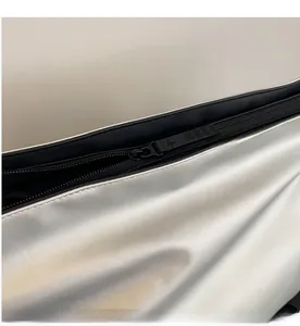 Détail macro de la fermeture éclair en métal noir fluide sur le sac de sport argenté
