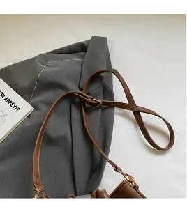 Detail of brown leather shoulder strap with gold metal buckle and adjustable holes