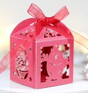 Détail de boîte à bonbons rouge de Pâques avec poussin découpé et ruban de soie