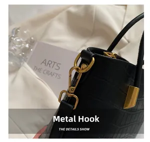Detail showing the black croc-embossed texture and premium gold-tone hardware hook