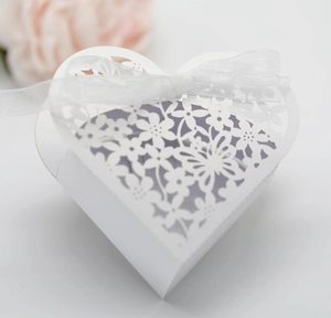 Detailed laser-cut white heart wedding favor box with intricate butterfly and floral patterns