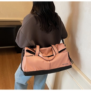 Détail du sac de sport rose et noir en tissu imperméable avec une bandoulière réglable