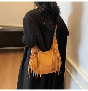 Detail view of brown suede hobo bag with long fringes and vintage bohemian style