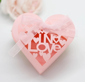 Top view of pink heart-shaped paper gift box with laser-cut IN LOVE design and ribbon