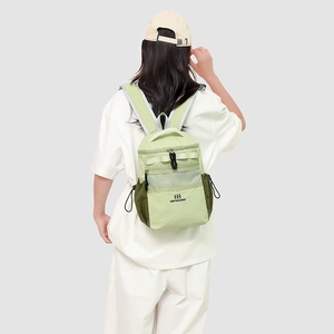 Detail of green two-tone nylon backpack with mesh pocket and drawstring side pouches