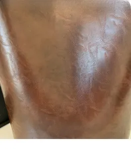 Gros plan sur la texture du cuir marron à grain naturel pour grand sac fourre-tout