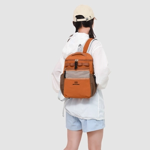 Detail view of the durable nylon backpack with orange and brown color-blocking design