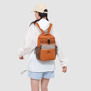 Outdoor leisure backpack in orange and brown nylon shown on model for back-view perspective