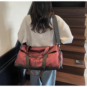 Grand sac de sport rose foncé avec sangles grises porté par un modèle en situation