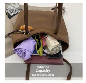 Spacious interior of brown pebbled leather tote bag holding an umbrella and books