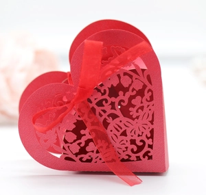 Detail of red heart laser-cut gift box with floral patterns and a red silk ribbon