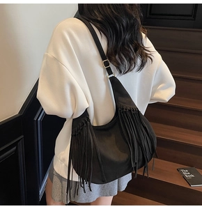 Détail de la frange noire et boucle dorée sur un sac hobo en cuir mat grande capacité