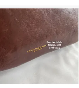 Macro shot of dark brown oil wax leather fabric with fashion logo and soft texture