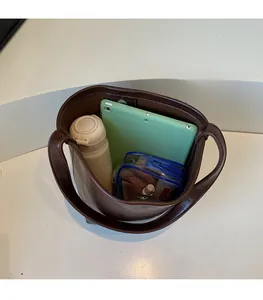 Vue de dessus du sac seau spacieux en cuir marron foncé montrant la grande capacité