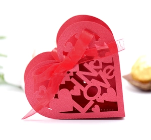 Detail of red hollowed-out Love heart candy box with laser-cut patterns and silk ribbon