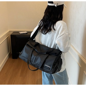 Sac de sport noir porté par un modèle avec bandoulière réglable et tissu durable