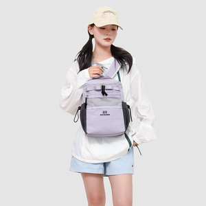 Detail of lavender nylon backpack with grey mesh pocket and adjustable straps on model