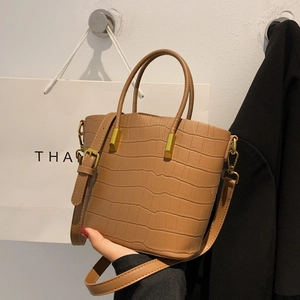 Detailed shot of caramel crocodile pattern leather tote bag with gold hardware accessories
